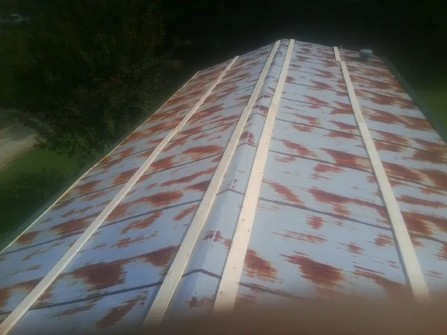 Rusted metal roof panels with new wood purlins before replacement — Storm Damage Roof Repair in Holloway by Roofing Brothers