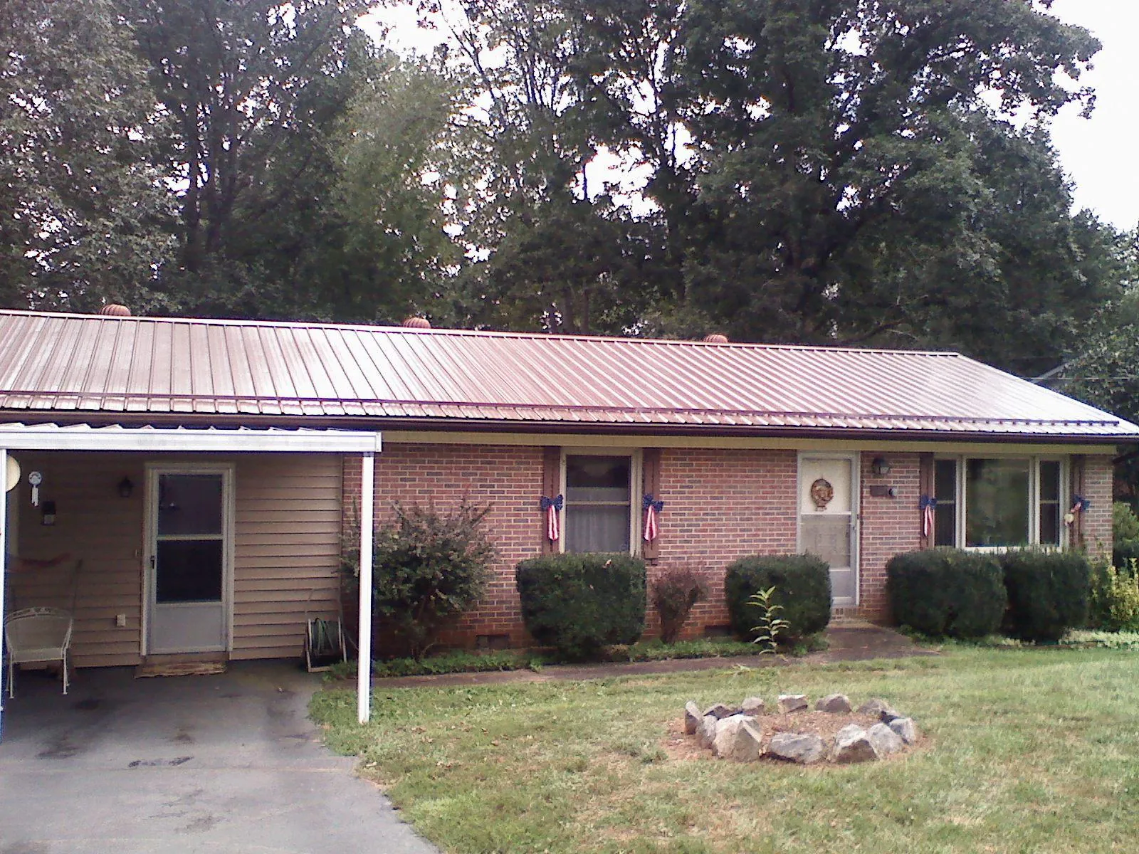 Bronze metal roof and carport on a brick ranch home — Roof Repair work by our crew in Holloway
